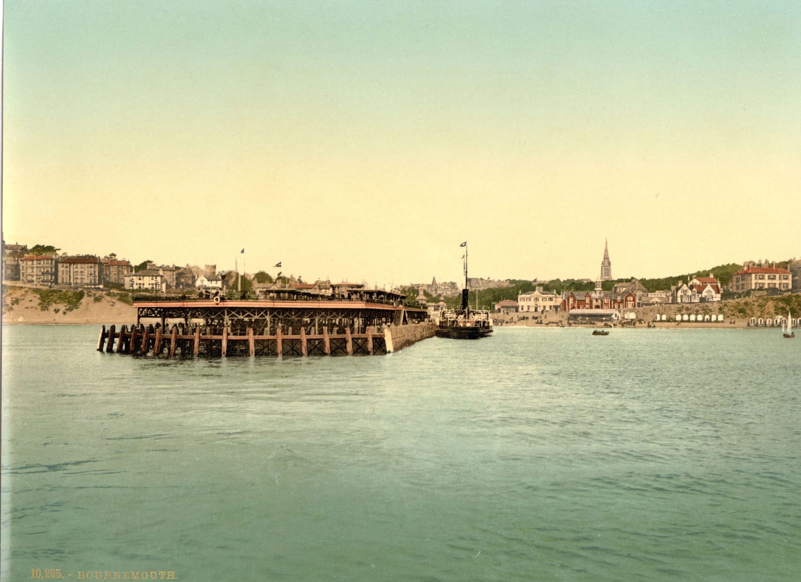 The pier and the town of Bournemouth seen across calm water from out in the bay.