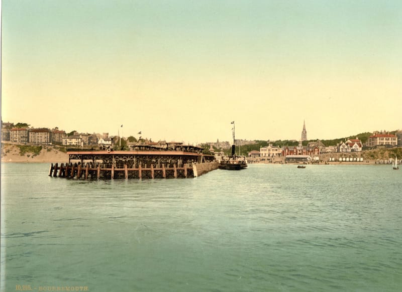 The pier and the town of Bournemouth seen across calm water from out in the bay.