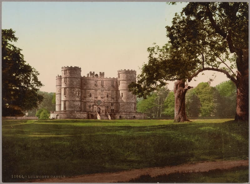 The square, turreted Lulworth Castle standing in open parkland under great trees.