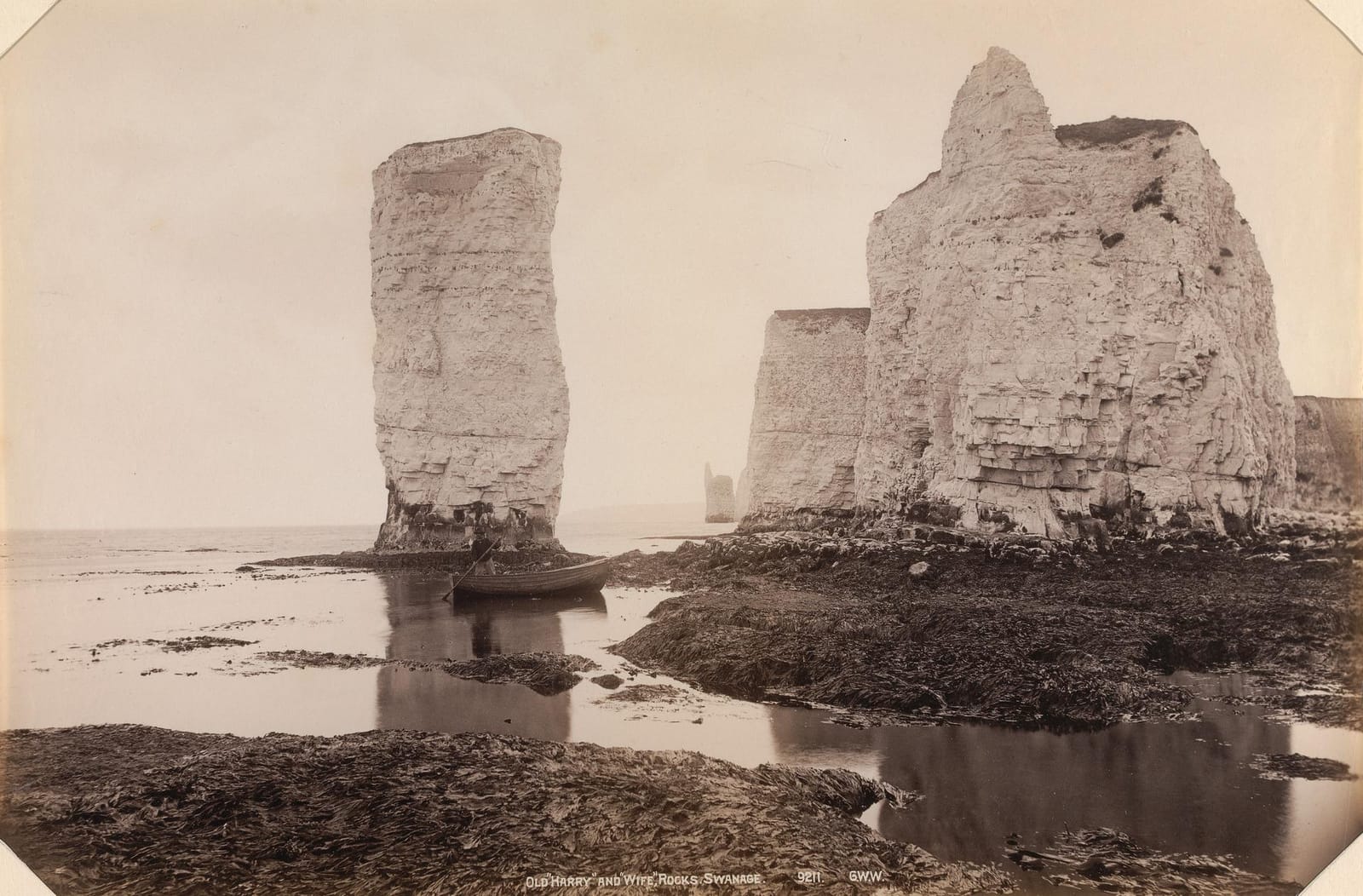 A photograph of the white chalk stacks of Old Harry standing in the sea off the cliffs.