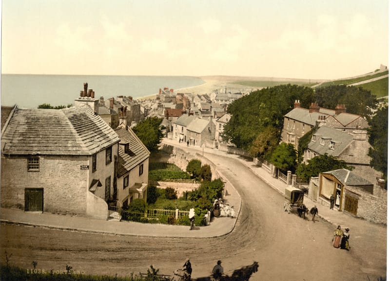 A steep village street of stone cottages winding down towards the sea.