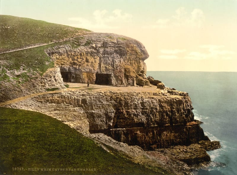Pale limestone cliffs with the openings of old quarry caves, dropping straight into the sea.